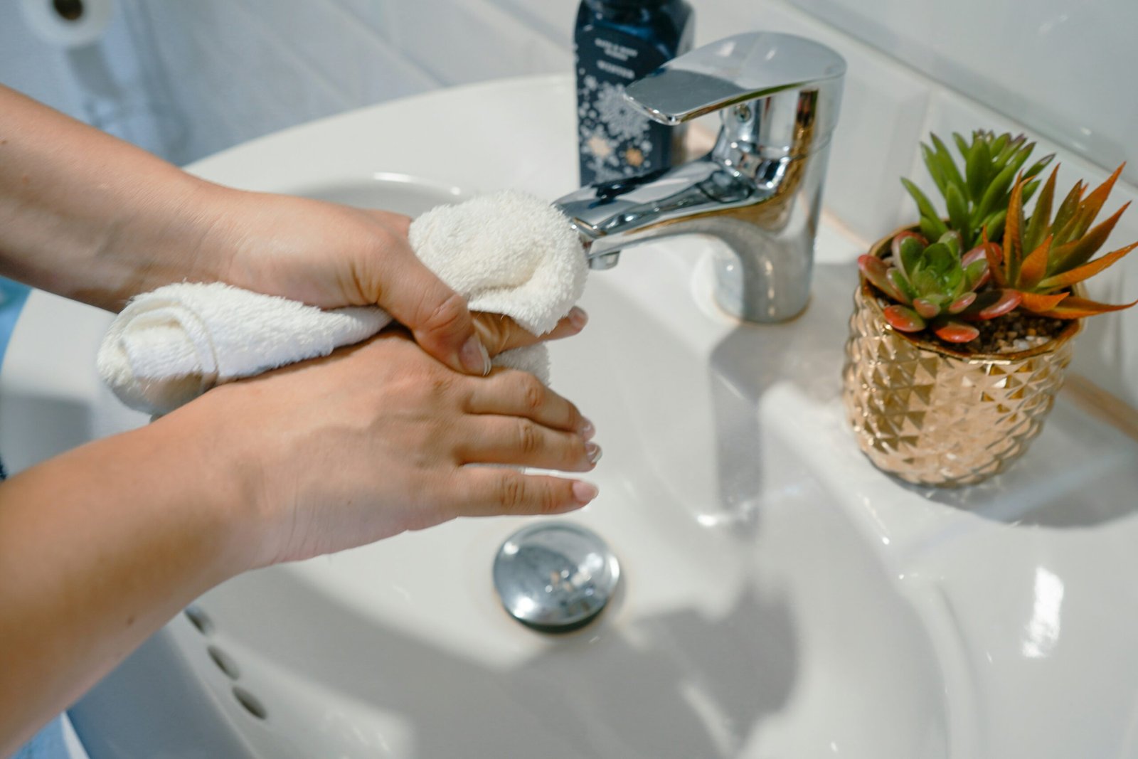 a person washing their hands in a sink scaled